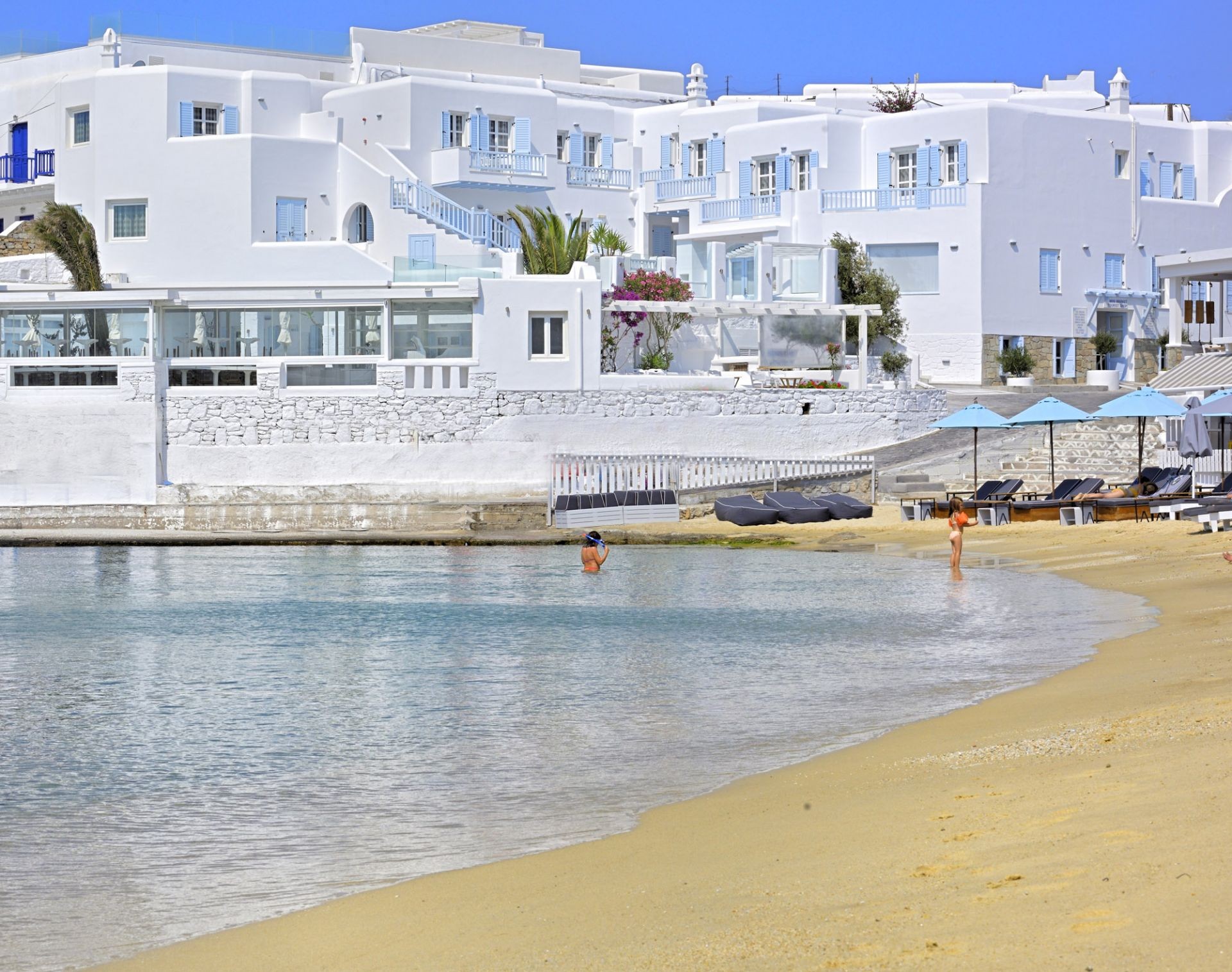 Plage de sable fin et pieds dans l'eau pour le Petinos Beach 4étoiles sur l'île de Mykonos dans les Cyclades en Grèce