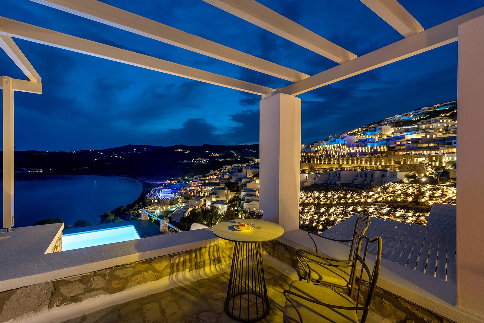 Vue de nuit depuis la terrasse de la Suite Lune de Miel à l'hôtel Cova Mykonos Suites sur l'île de Mykonos et de Elia Beach